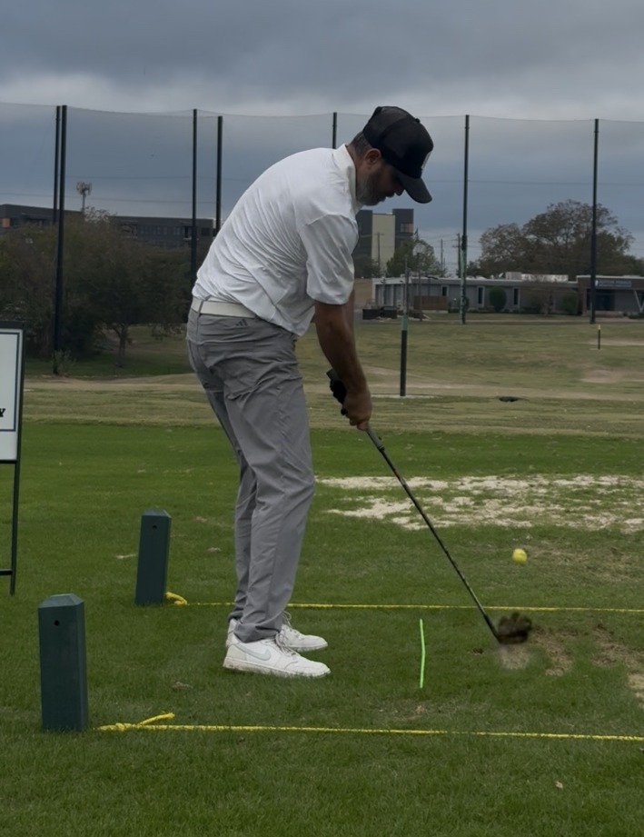 Simon Fagan striking an iron shot on the practice range